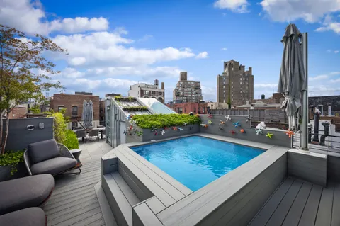 a view of a rooftop deck with couch and chairs