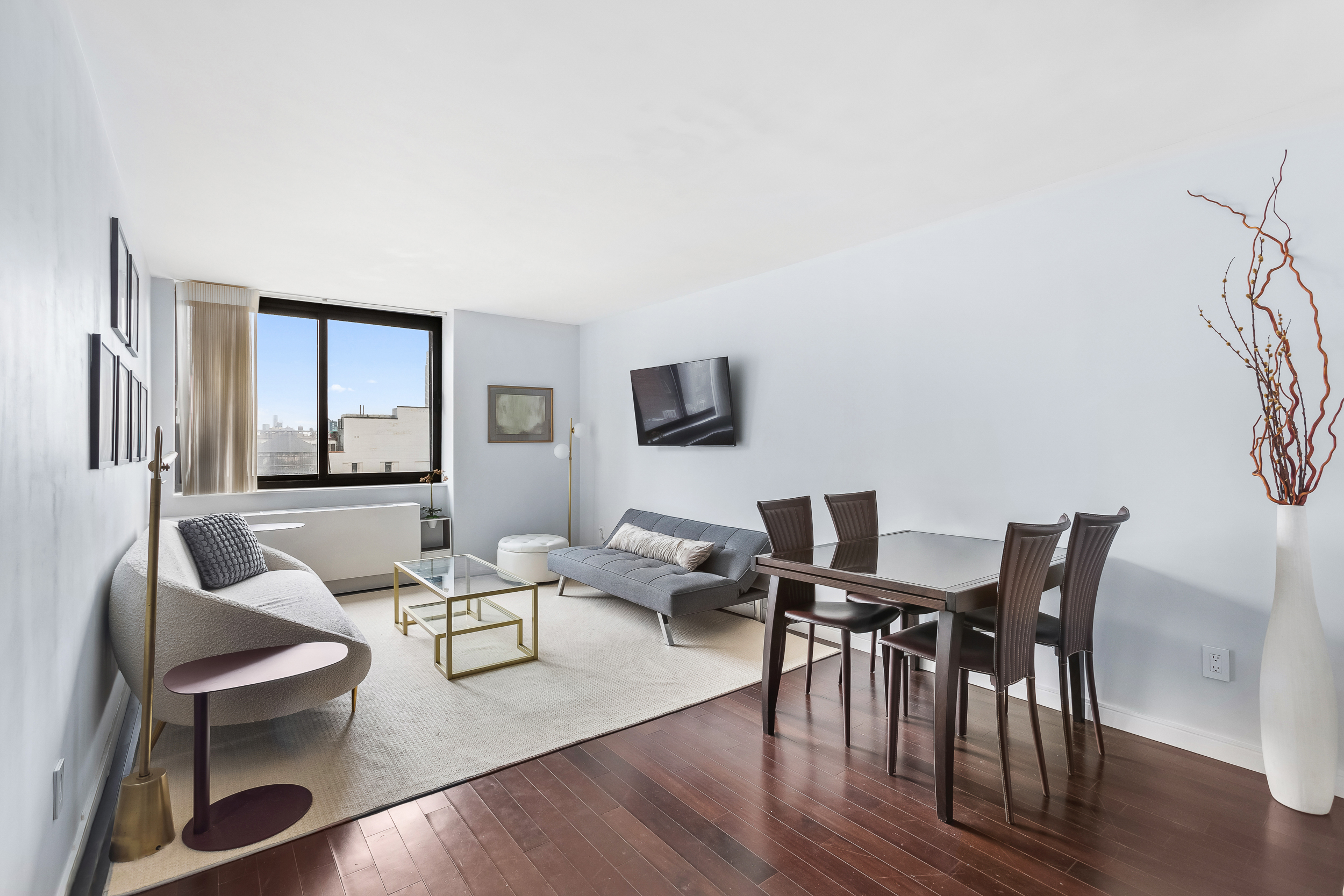 376 Broadway, Unit 14E Manhattan, NY 10013 - Photo 1 of 11 a living room with furniture wooden floor and a flat screen tv