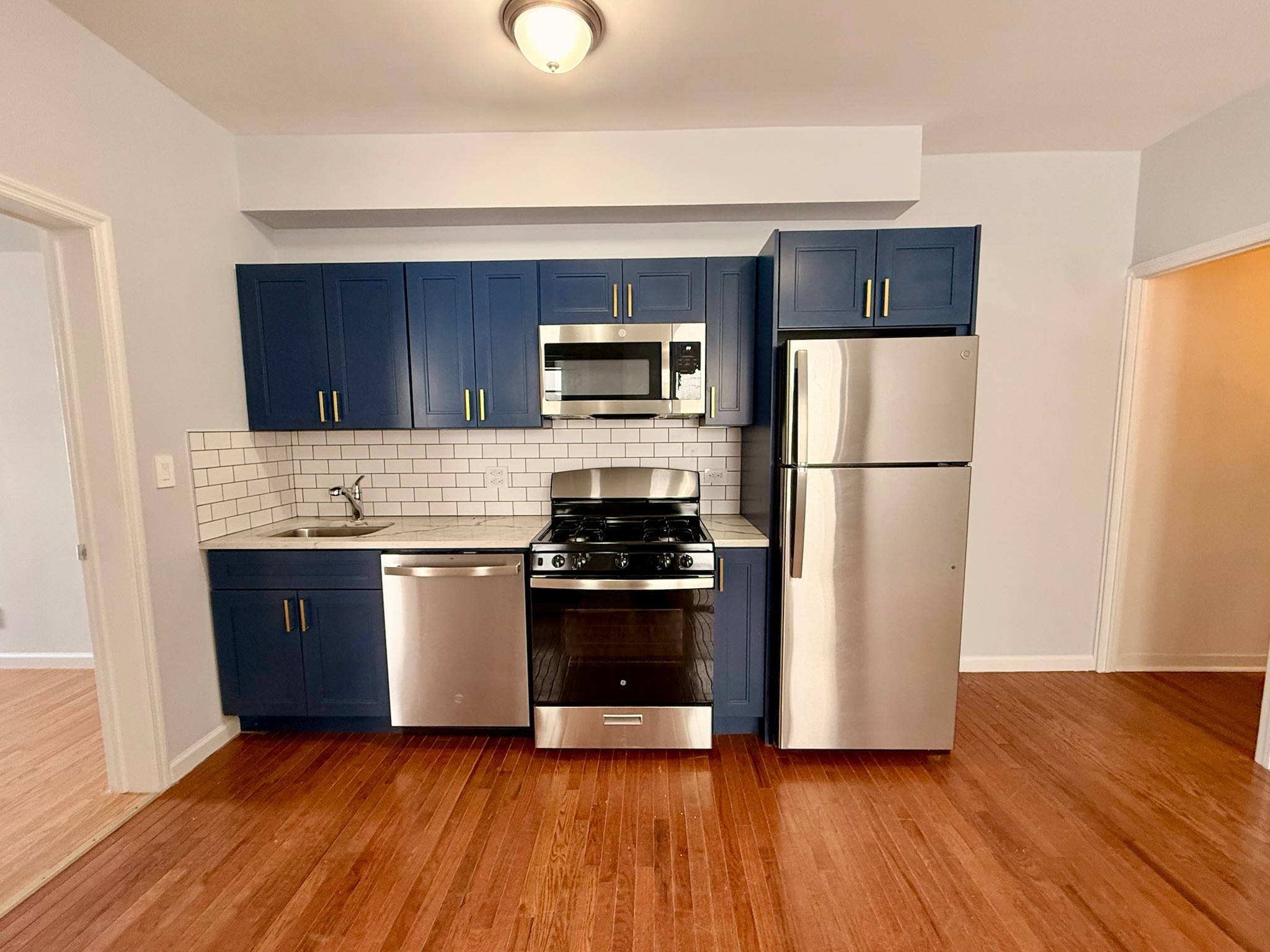 a kitchen with a refrigerator stove and wooden cabinets