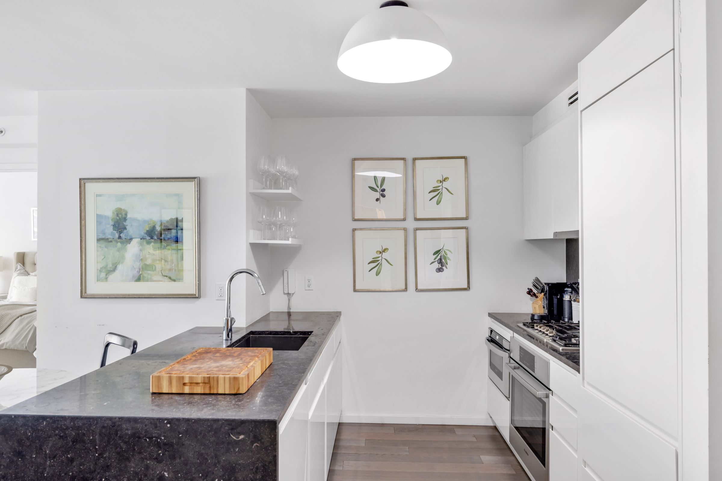 385 1st Avenue, Unit 4B Manhattan, NY 10010 - Photo 5 of 18 a kitchen with stainless steel appliances granite countertop a sink stove and cabinets