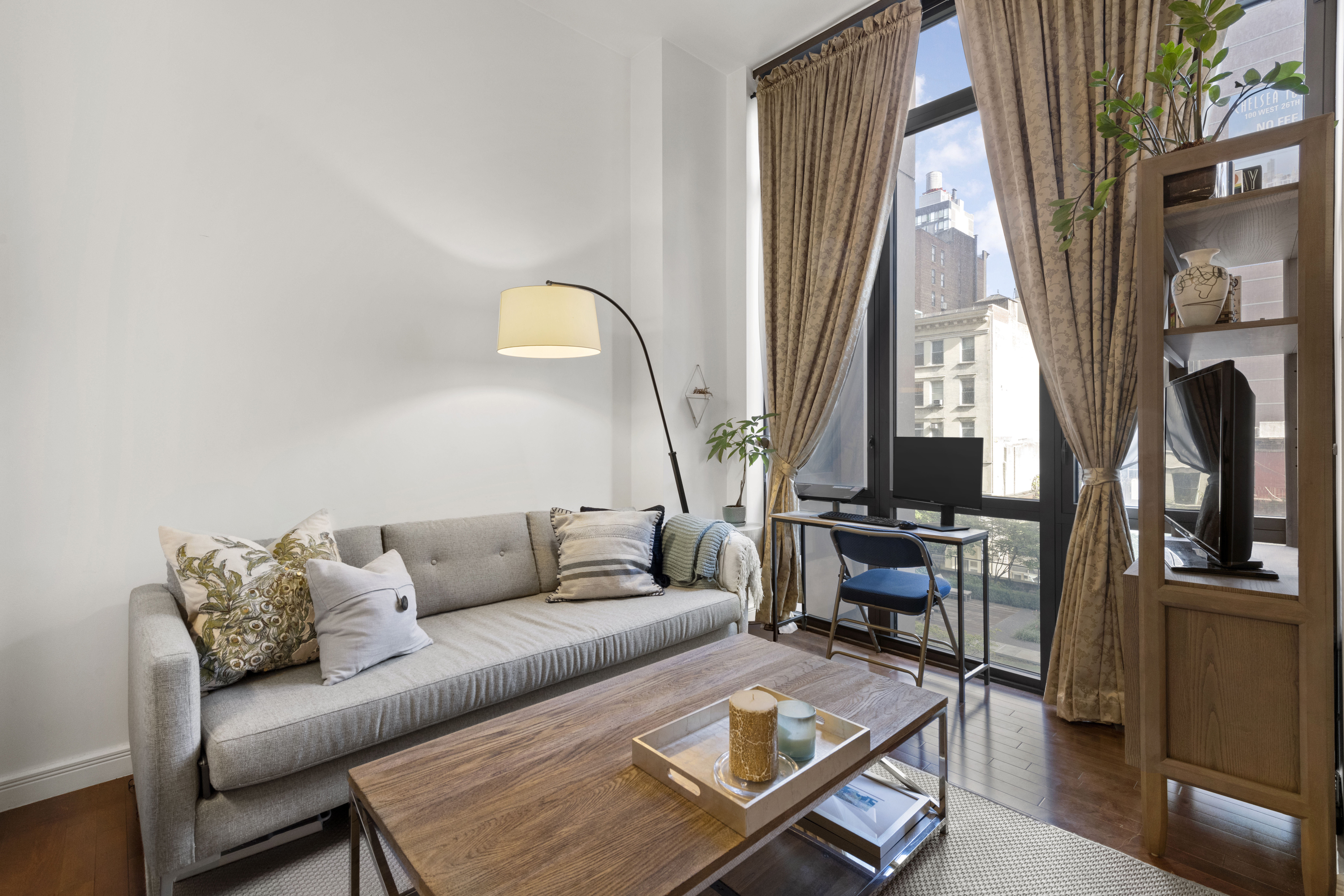 101 West 24th Street, Unit 5G Manhattan, NY 10011 - Photo 2 of 16 a living room with furniture a fireplace and a large window