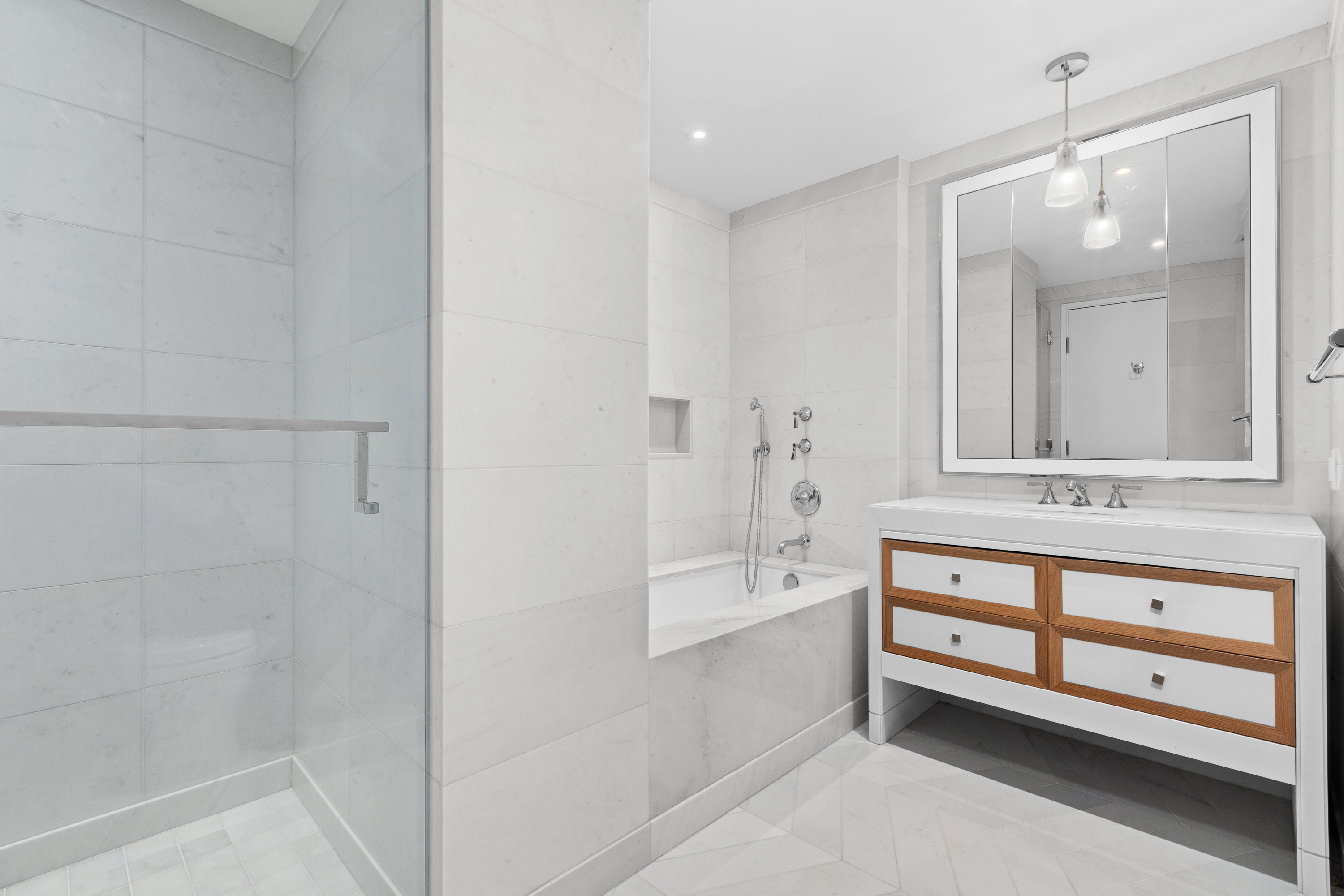 212 Warren Street, Unit 20A Manhattan, NY 10282 - Photo 15 of 23 a bathroom with a bathtub a sink and a mirror