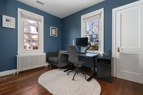 a view of a workspace with furniture and a window