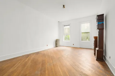 an empty room with window and wooden floor