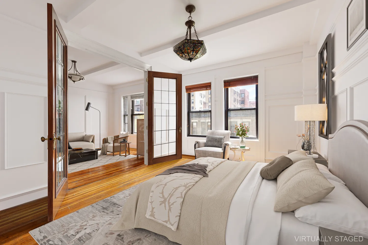 a large bedroom with a bed a chandelier and large window