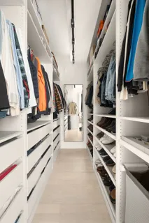 a view of walk in closet with clothes and shoes