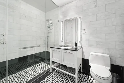 a bathroom with a granite countertop toilet a sink and a shower