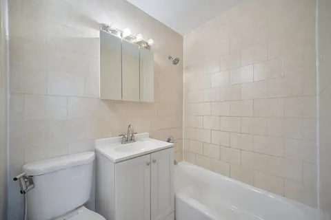 a bathroom with a sink toilet vanity and bathtub
