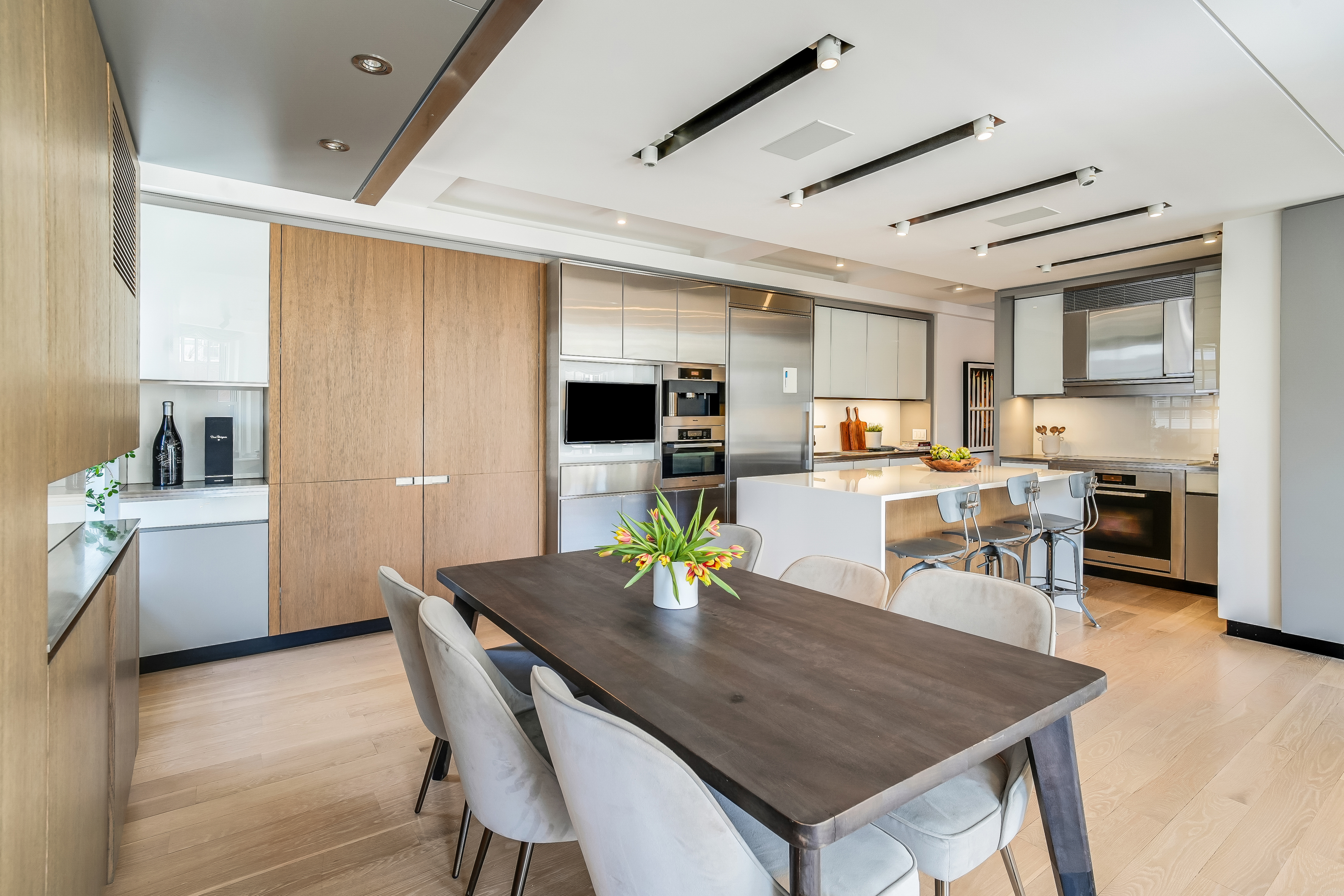 1 5th Avenue, Unit 5GH Manhattan, NY 10003 - Photo 9 of 26 a kitchen with a table chairs and a refrigerator