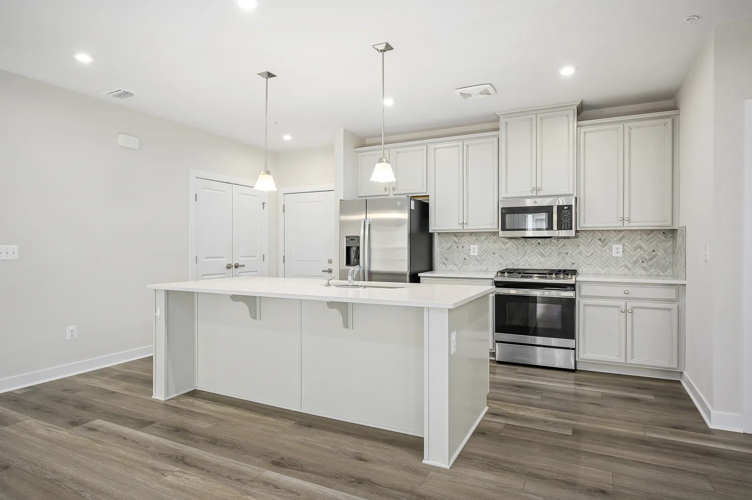 a kitchen with kitchen island a sink stainless steel appliances and cabinets