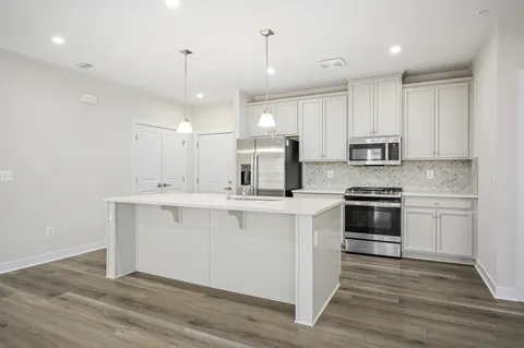 a kitchen with kitchen island a sink stainless steel appliances and cabinets