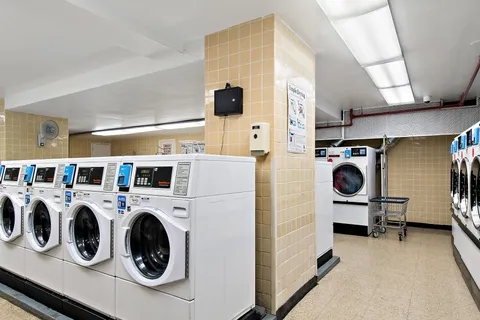 a utility room with dryer washer and a view of living room