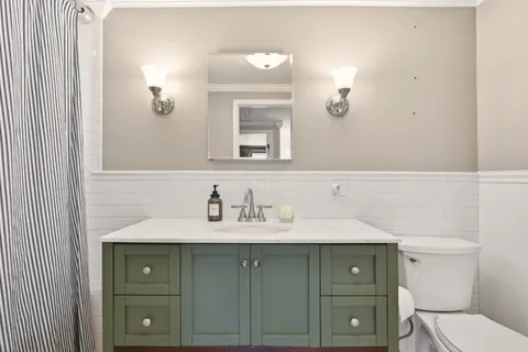 a bathroom with a sink a toilet and mirror