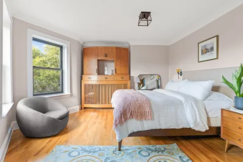 a bedroom with furniture and a large window