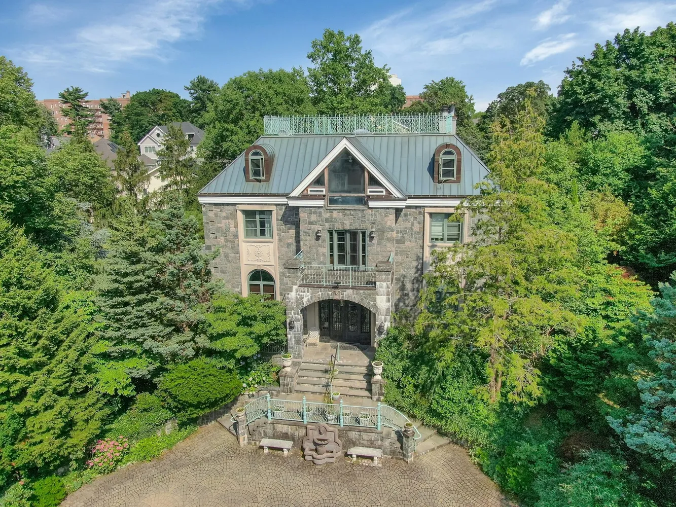 an aerial view of a house with a small yard plants and large trees