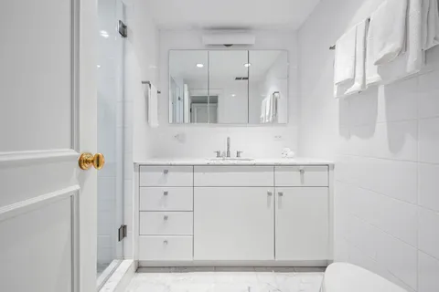 a bathroom with a granite countertop sink toilet and shower