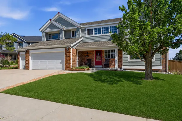 a front view of a house with a yard and trees