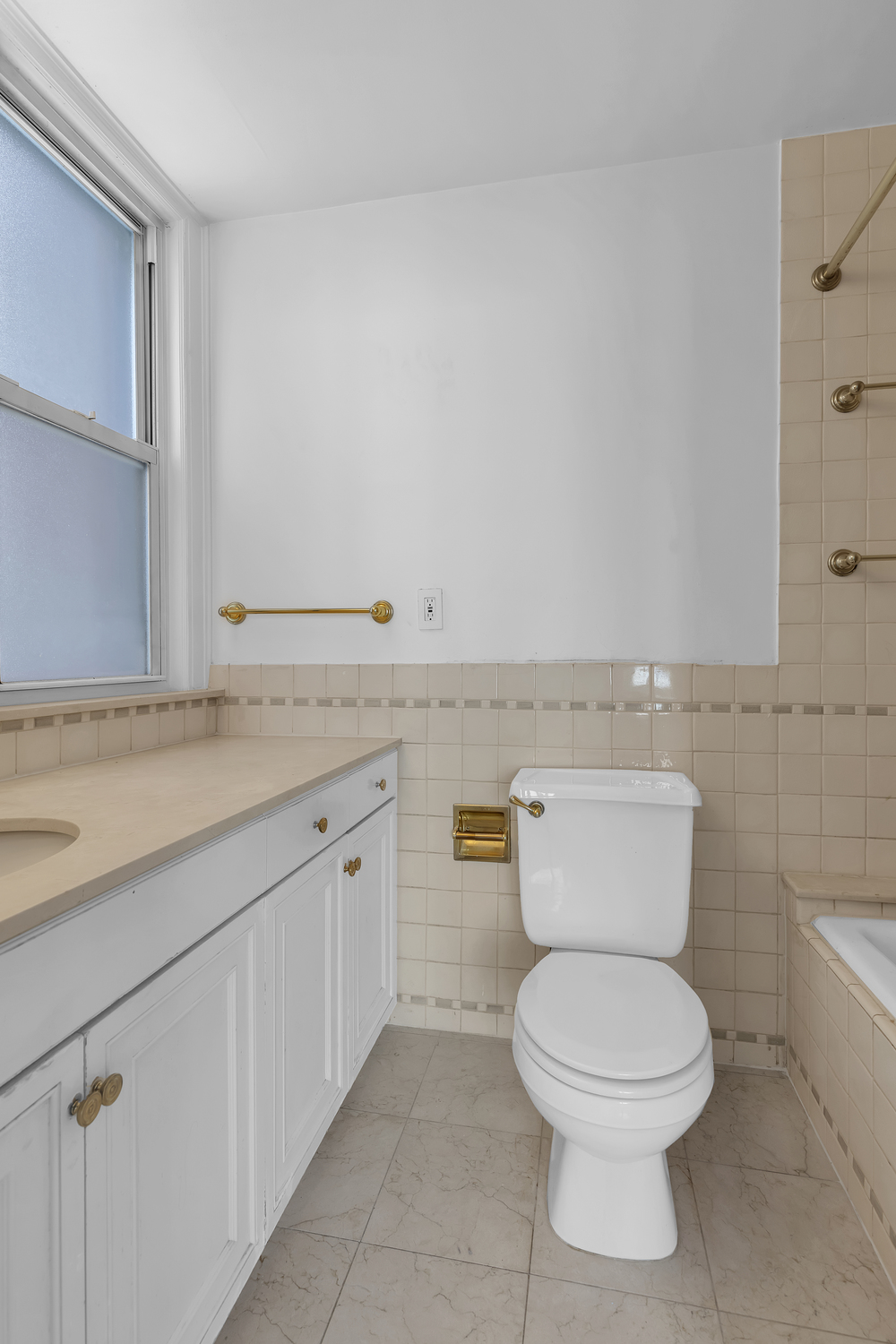 1045 Park Avenue, Unit 5A Manhattan, NY 10028 - Photo 7 of 10 a bathroom with a granite countertop toilet and a sink