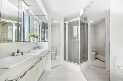 a bathroom with a double vanity sink toilet and shower