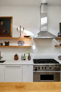 a kitchen with a stove and wooden floor