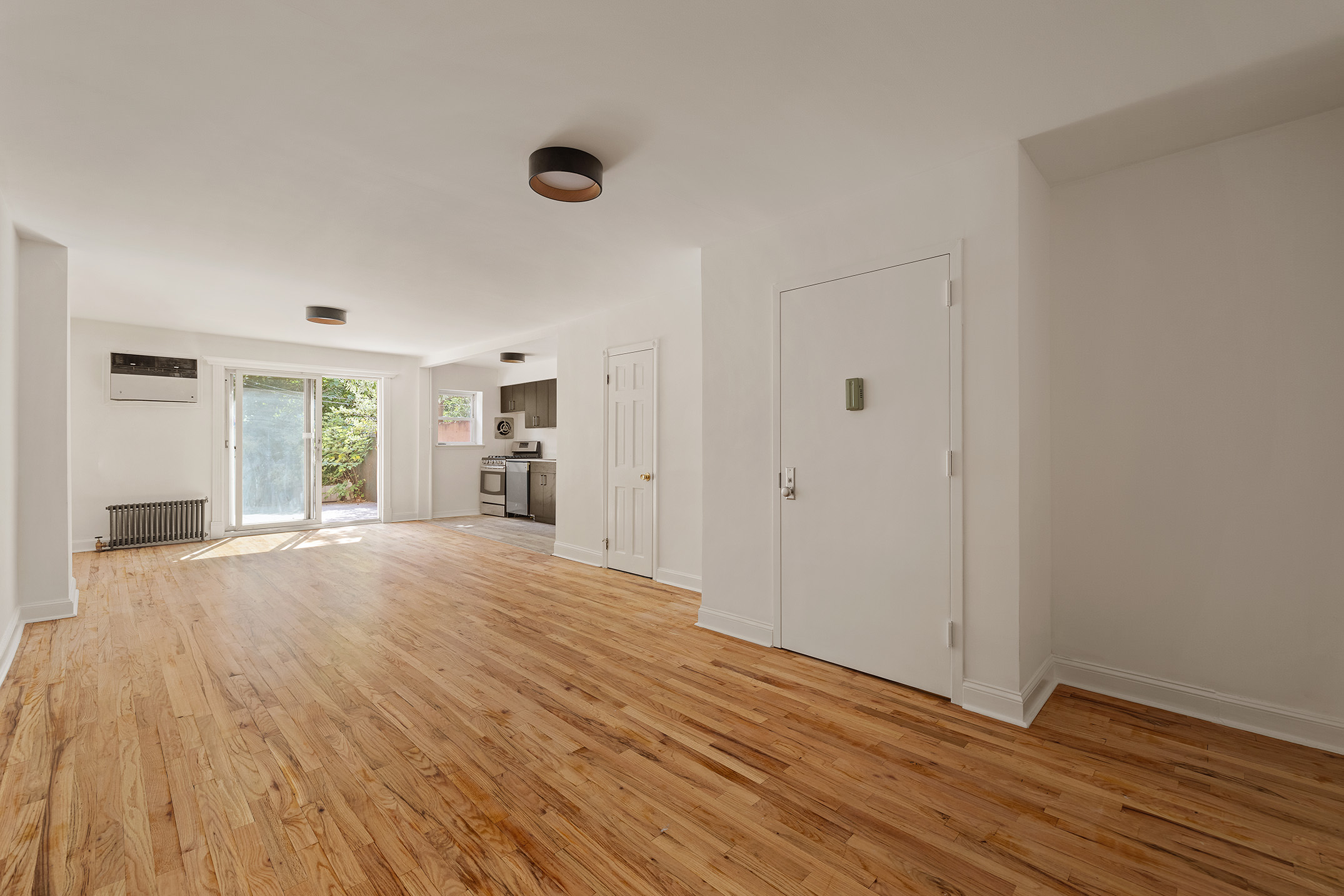 a view of empty room with wooden floor and window