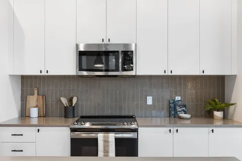 a kitchen with stainless steel appliances granite countertop a stove a microwave and cabinets