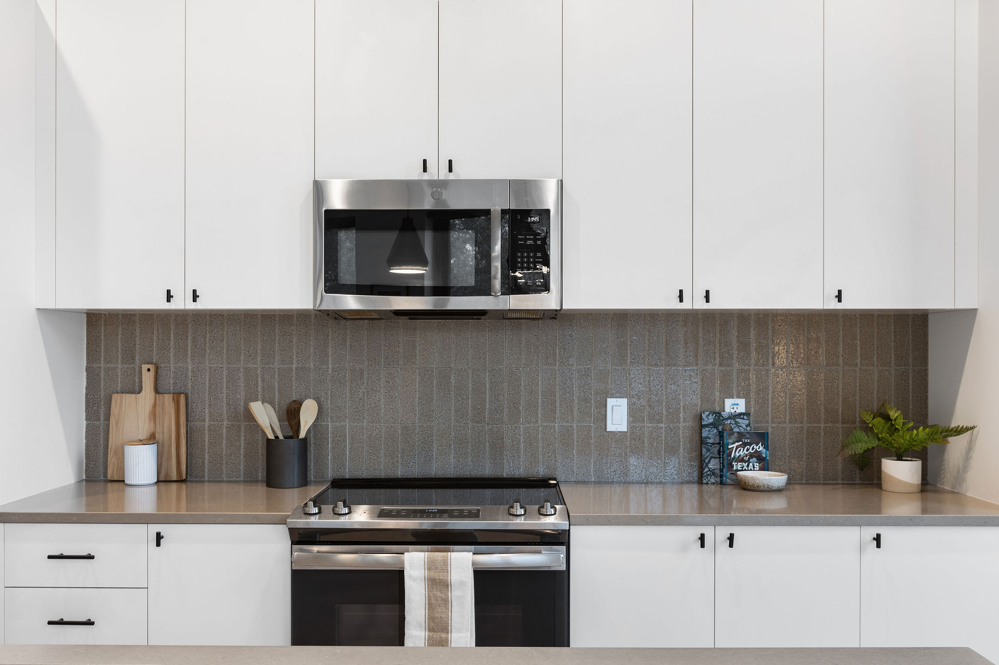 800 Embassy Drive, Unit 236 Austin, TX 78702 - Photo 42 of 50 a kitchen with stainless steel appliances granite countertop a stove a microwave and cabinets