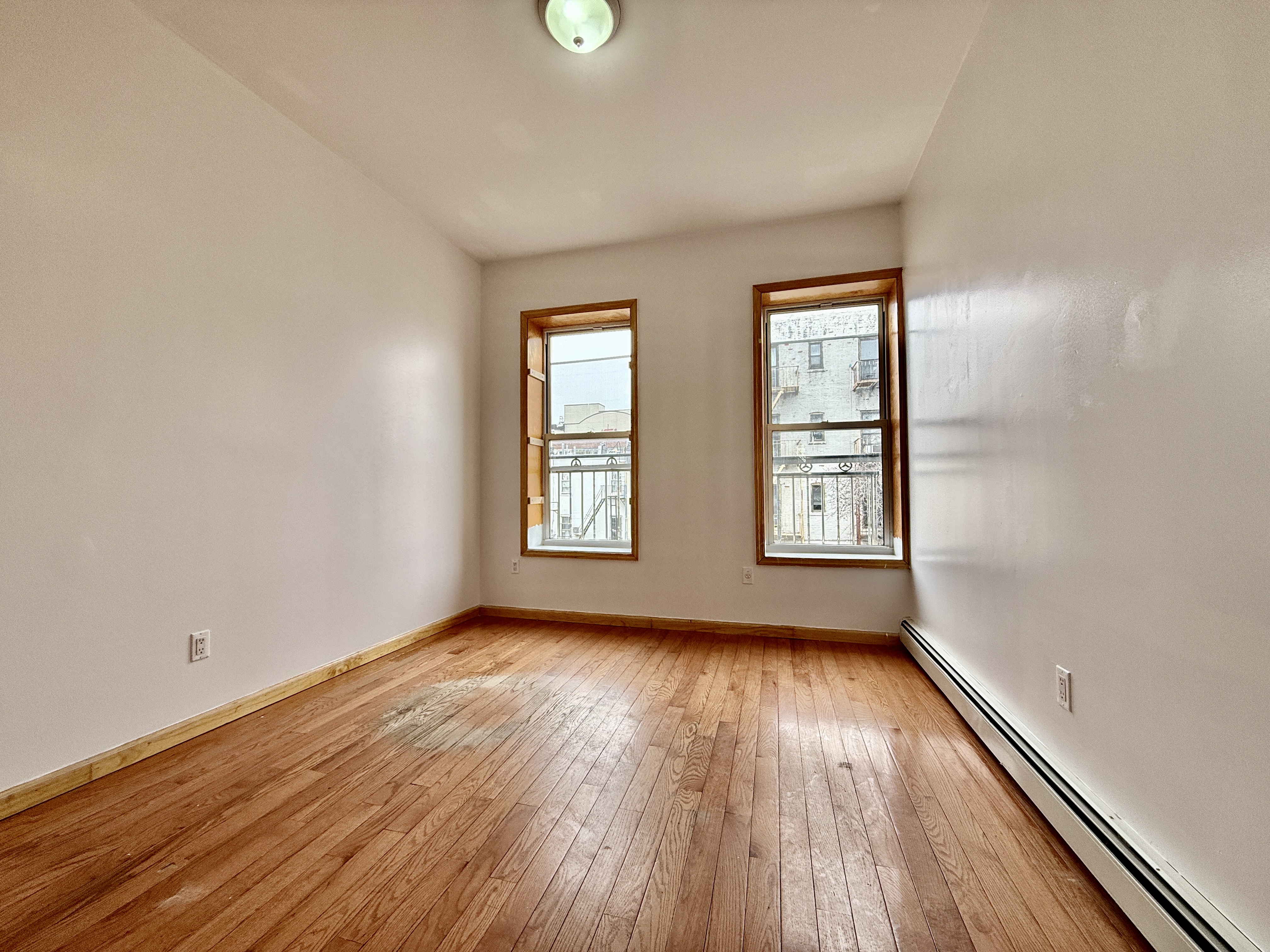 543 53rd Street, Unit 1 Brooklyn, NY 11220 - Photo 4 of 8 an empty room with wooden floor and windows