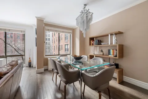 a dining room with furniture a chandelier and wooden floor