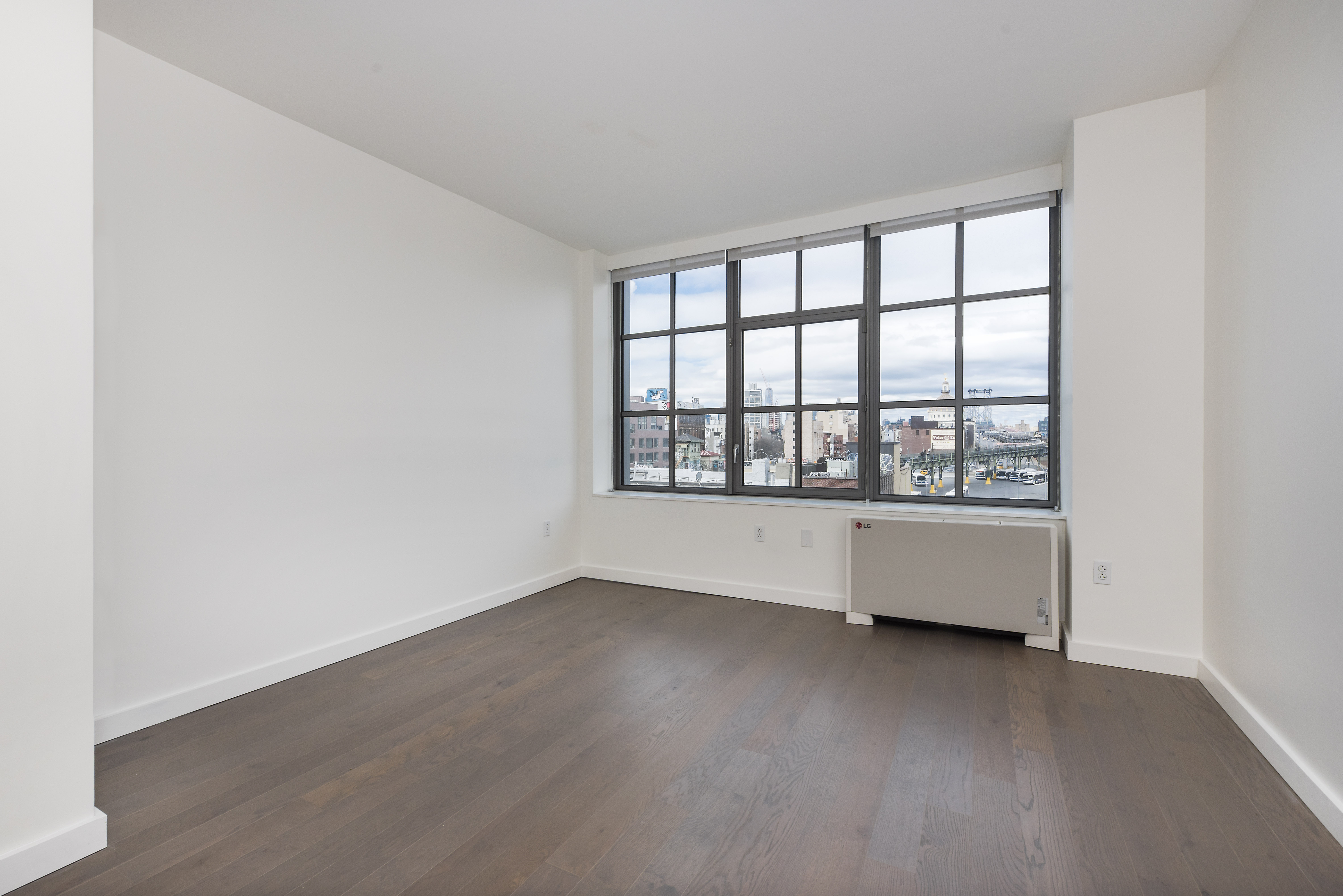 282 South 5th Street, Unit 7F Brooklyn, NY 11211 - Photo 2 of 16 an empty room with wooden floor and windows