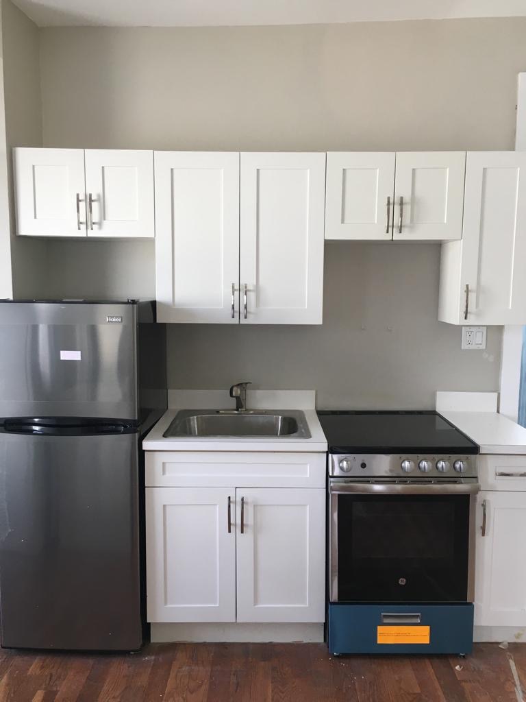 342 East 9th Street Brooklyn, NY 11218 - Photo 3 of 12 a kitchen with a stove and a refrigerator