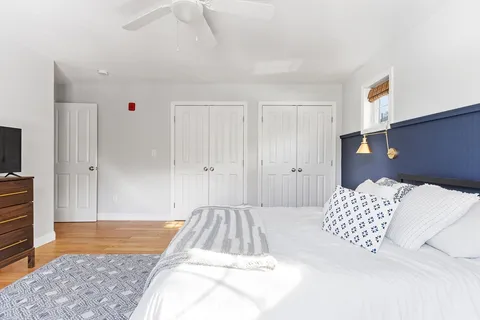 a spacious bedroom with a bed and wooden floor