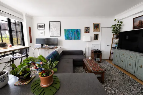 a living room with furniture a flat screen tv and a potted plant