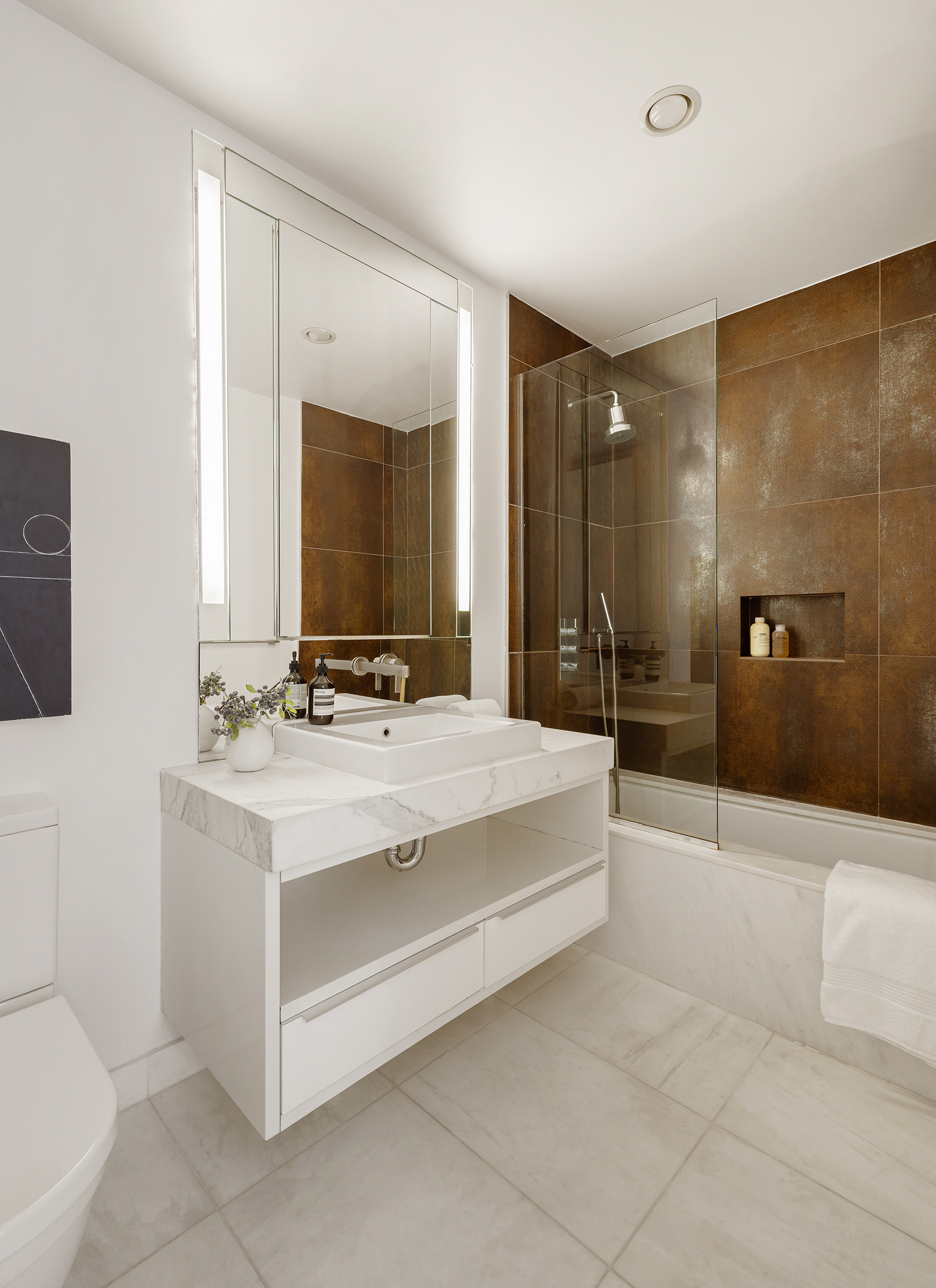 133 West 22nd Street, Unit 8C Manhattan, NY 10011 - Photo 6 of 11 a bathroom with a sink a toilet and mirror