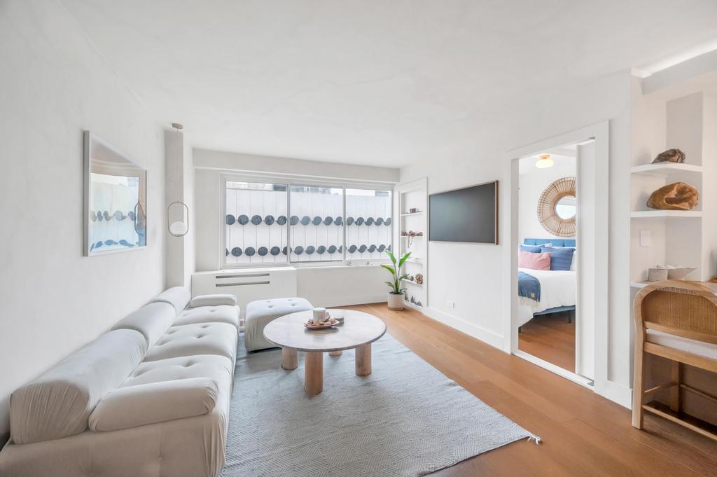 175 West 12th Street, Unit 5E Manhattan, NY 10011 - Photo 9 of 22 a living room with furniture and a flat screen tv