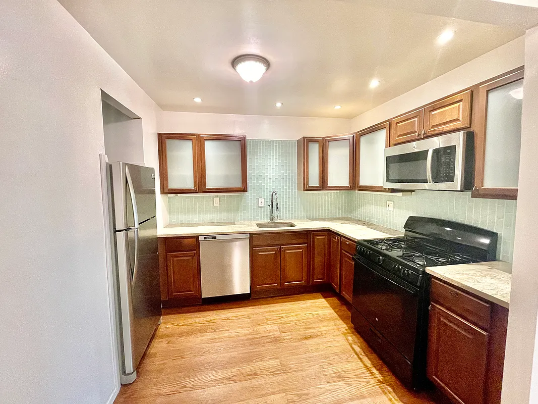 25-92 36th Street, Unit 2 Queens, NY 11103 - Photo 3 of 7 a kitchen with granite countertop stainless steel appliances and wooden cabinets
