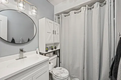 a bathroom with a sink a toilet and a mirror