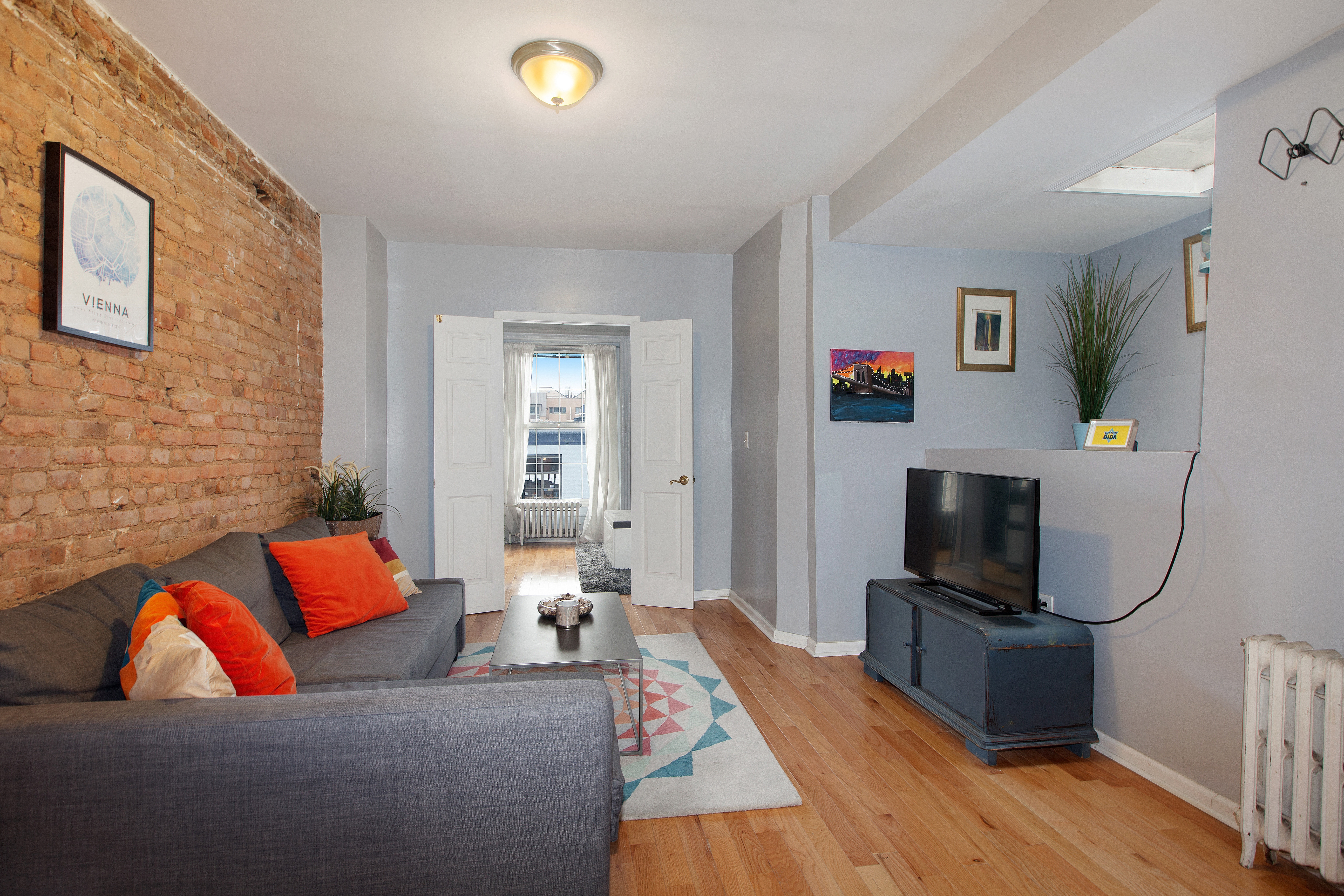 250 Saint Marks Avenue, Unit 3 Brooklyn, NY 11238 - Photo 5 of 8 a living room with furniture and a flat screen tv