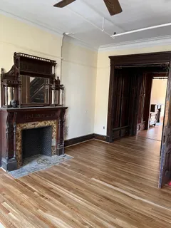 a view of a livingroom with wooden floor and a fireplace