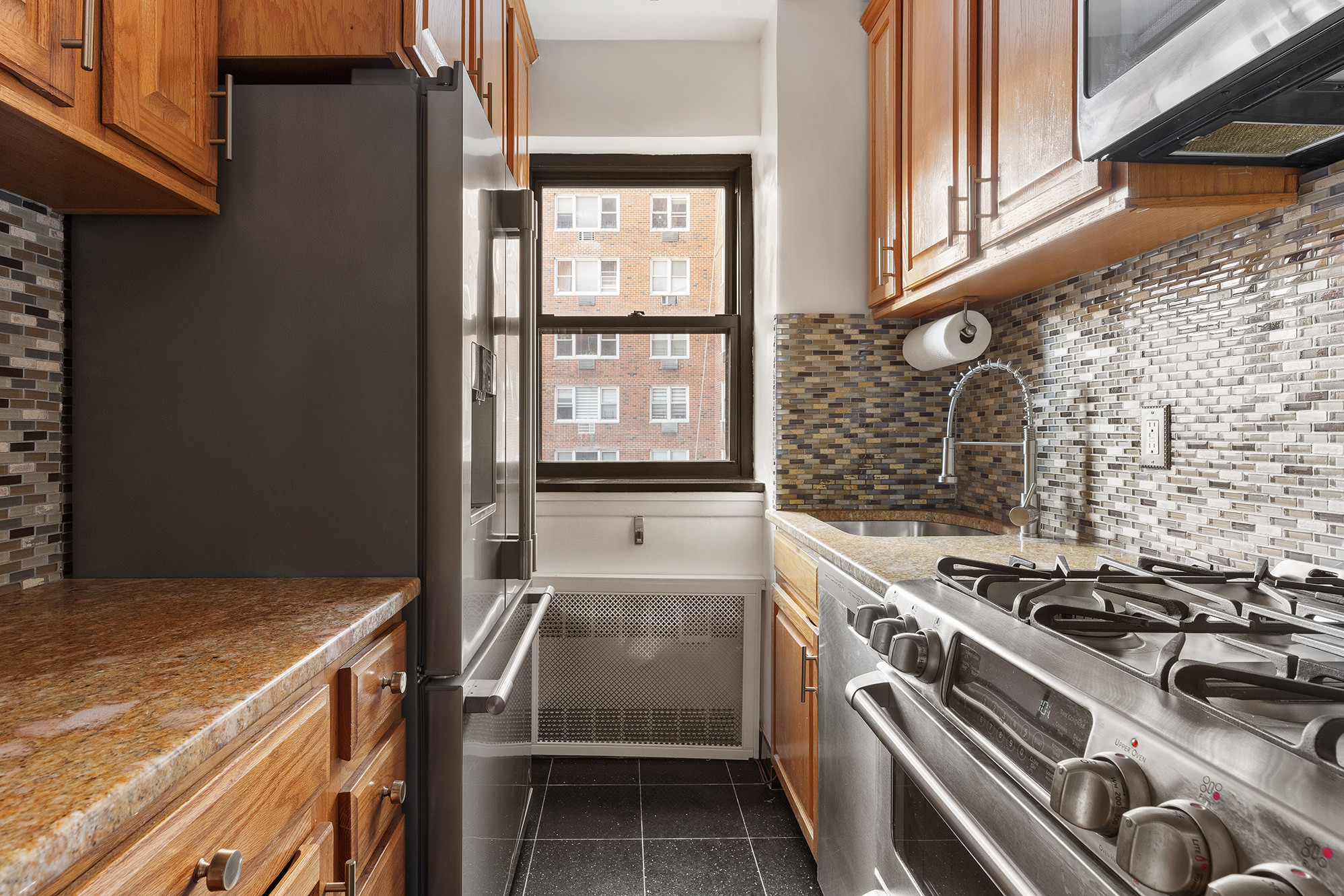 181 East 73rd Street, Unit 9G Manhattan, NY 10021 - Photo 14 of 17 a kitchen with a stove and a white cabinet