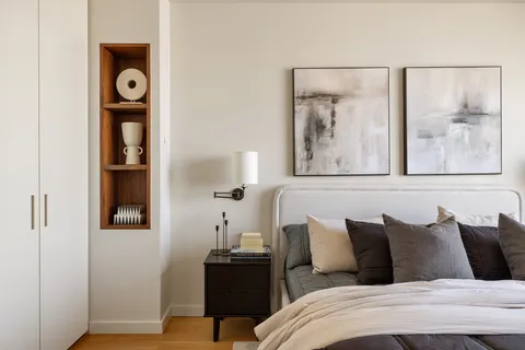 a bed room with a bed and painting on the wall