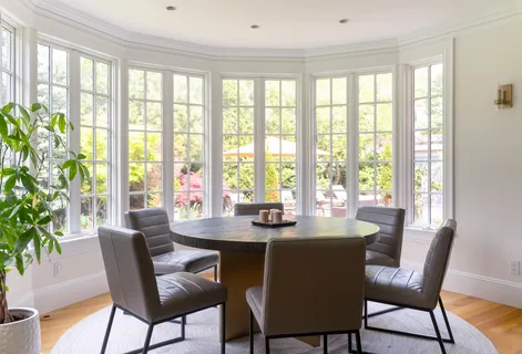 a dining room with furniture and large windows