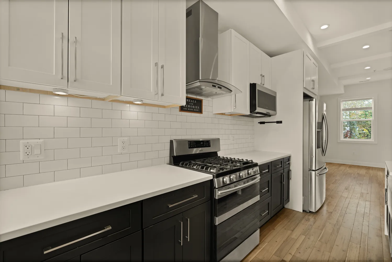 a kitchen with stainless steel appliances a stove a sink and white cabinets