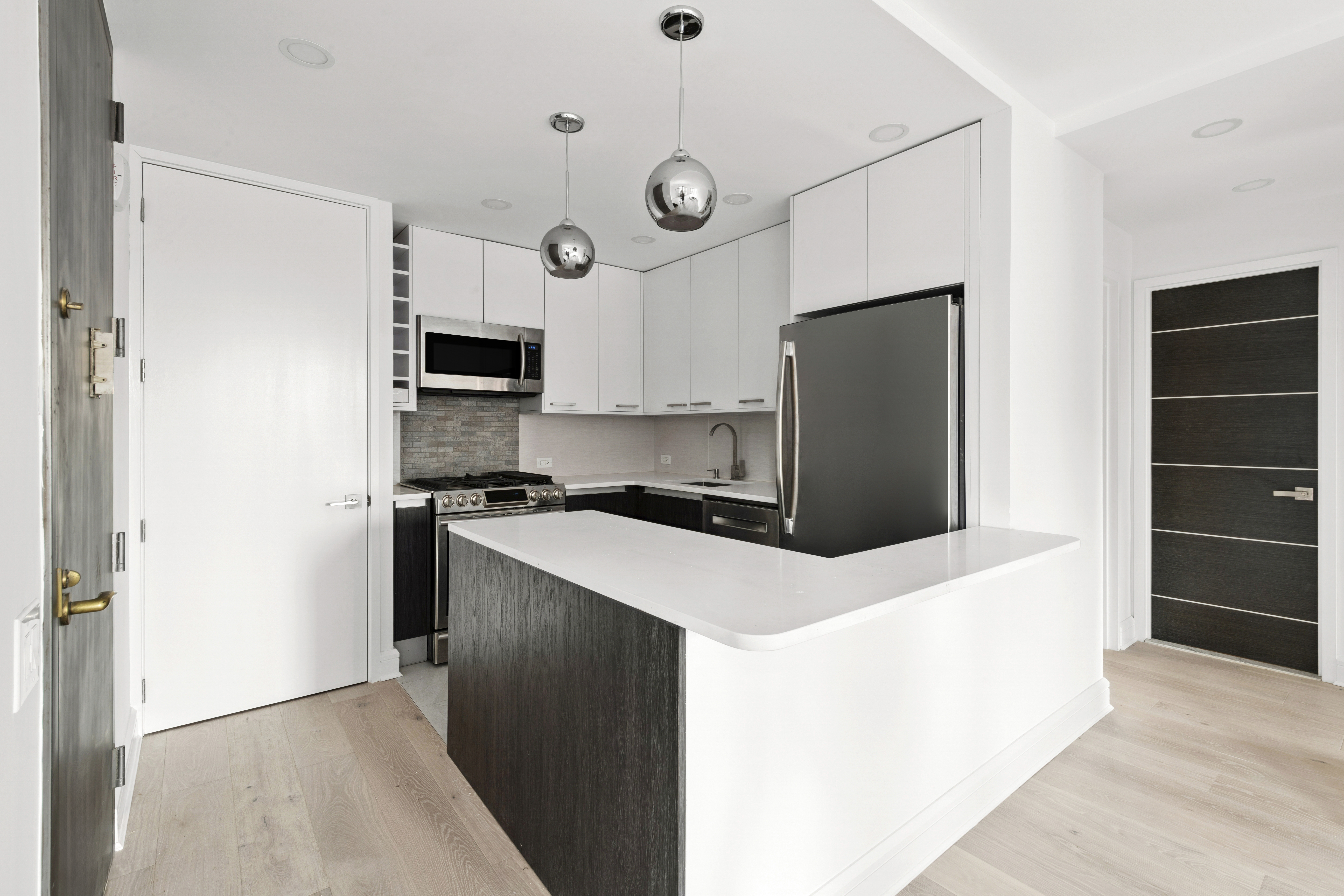 330 East 75th Street, Unit 5B Manhattan, NY 10021 - Photo 5 of 11 a kitchen with stainless steel appliances a refrigerator and a stove top oven