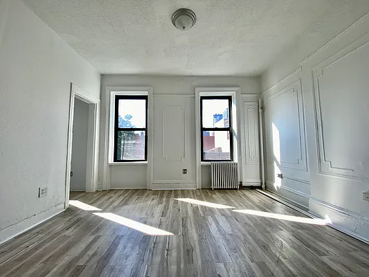 591 Vanderbilt Avenue, Unit 4 Brooklyn, NY 11238 - Photo 6 of 10 an empty room with wooden floor and windows