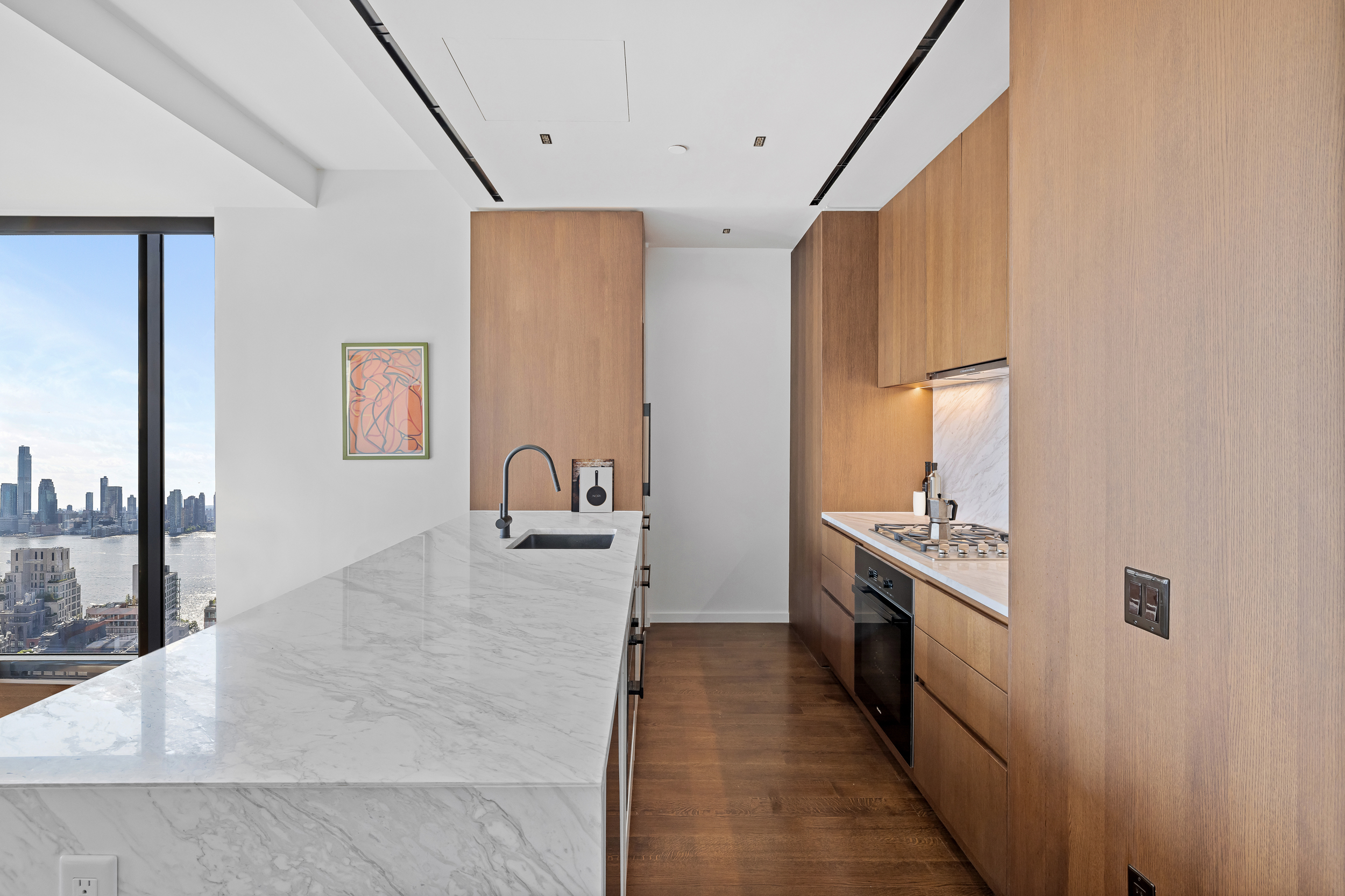 570 Broome Street, Unit 23A Manhattan, NY 10013 - Photo 4 of 13 a large white kitchen with stainless steel appliances granite countertop a lot of counter space and a sink