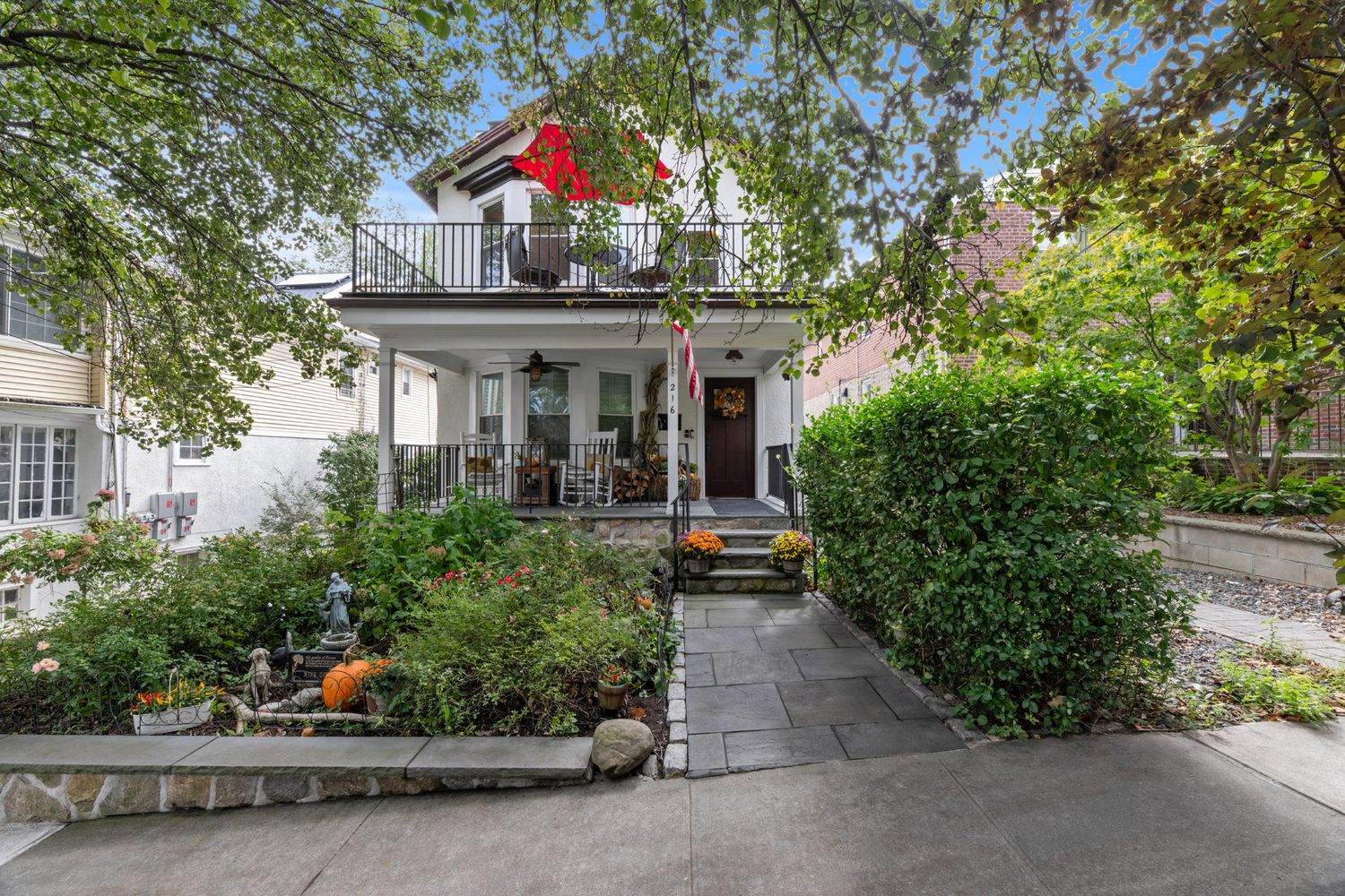a view of a brick house with potted plants and a bench