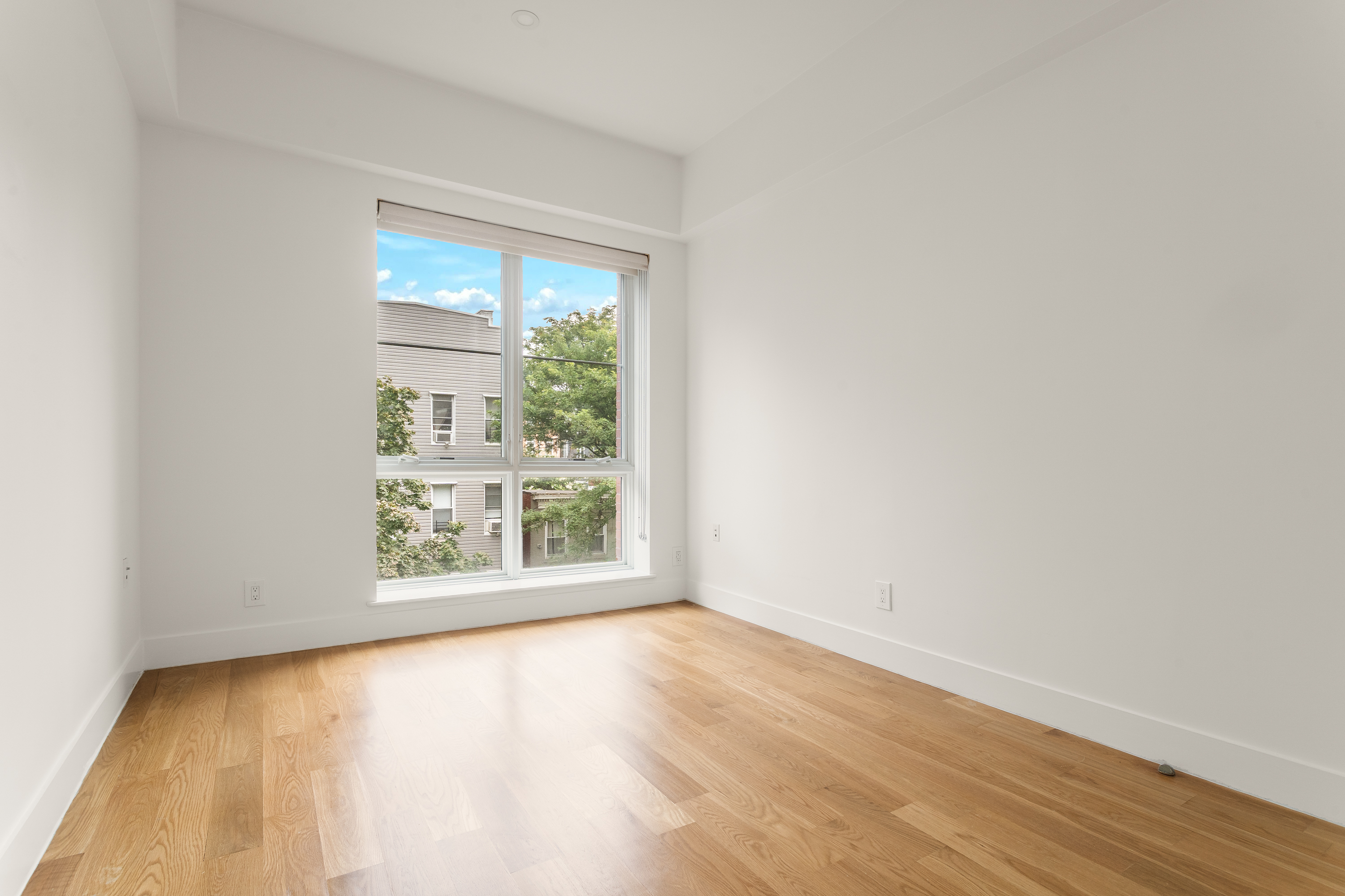 21 Powers Street, Unit 3A Brooklyn, NY 11211 - Photo 3 of 14 an empty room with wooden floor and windows
