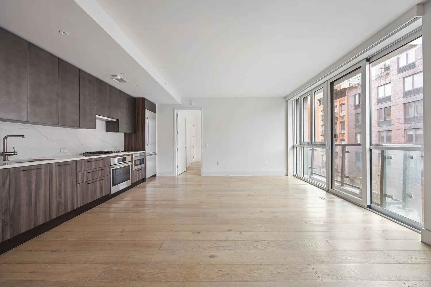a view of a kitchen with refrigerator and white cabinets