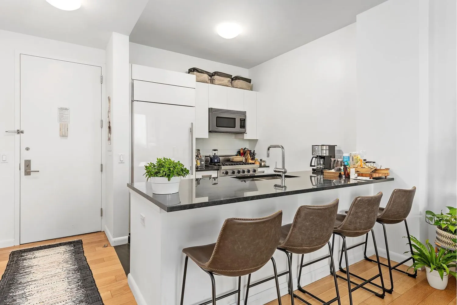 a kitchen with stainless steel appliances granite countertop a sink and a refrigerator